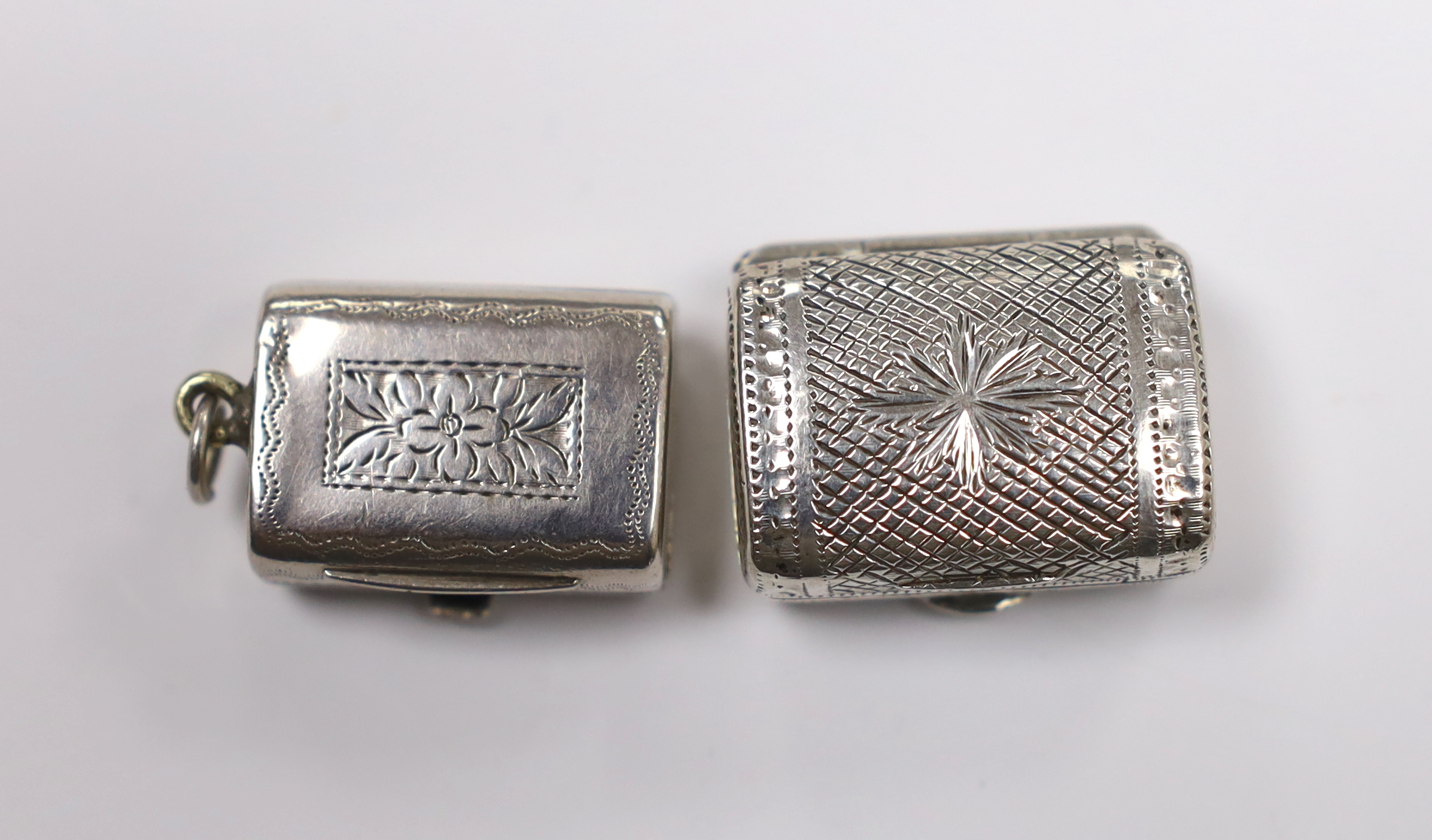 Two 19th century engraved silver vinaigrettes, modelled as satchels, John Lawrence & Co, Birmingham, 1817 and Thomas Simpson?, Birmingham, 1831, largest 24mm.